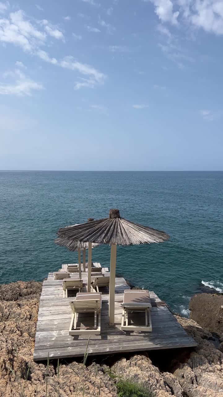 沙滩伞和海浪在夏天，垂直视频。视频素材