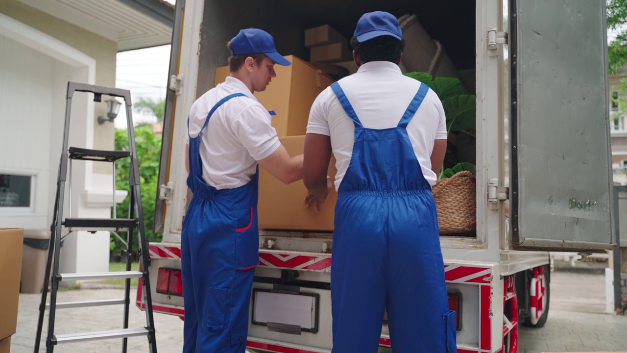 卡车搬运工装载货车，搬运箱子和搬家。两个送货员检查搬家服务的订单。视频下载