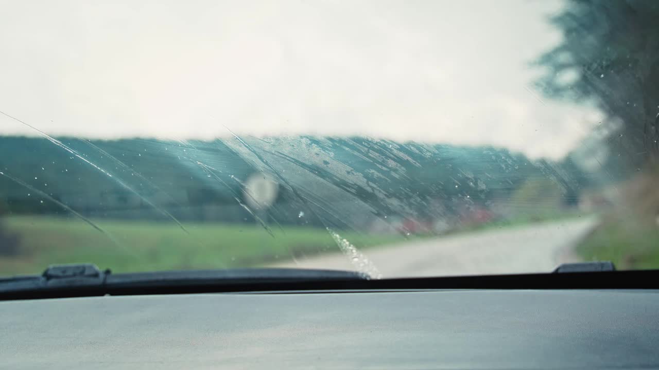 透过雨道上的挡风玻璃望去，雨刷正在运转。视频素材