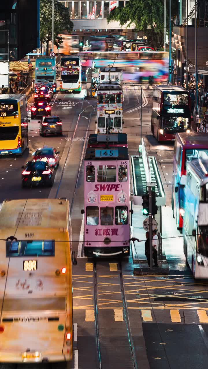 汽车、巴士、的士交通运输、华人、亚洲通勤人群夜间在香港中环过马路的垂直时程图。亚洲的交通生活方式，或城市都市生活视频素材