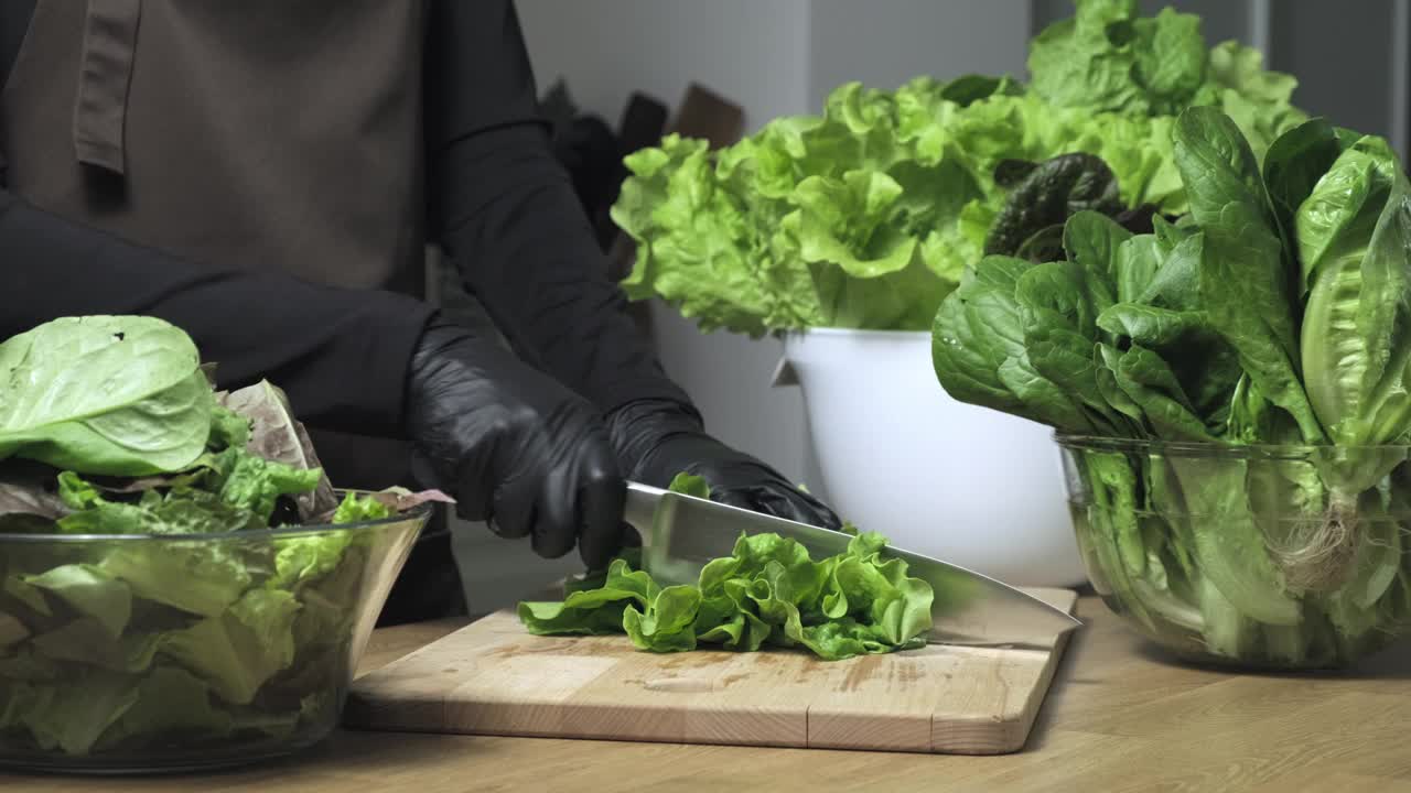 蔬菜沙拉。在家里的厨房里切生菜绿叶视频素材