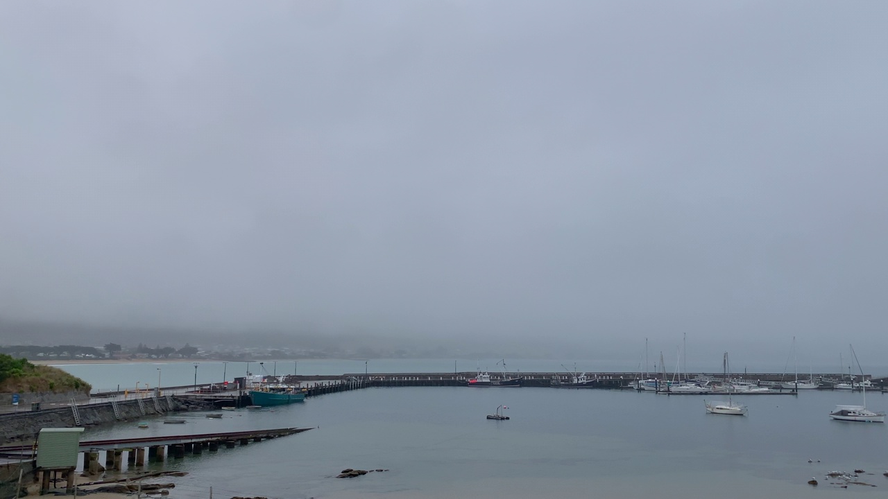 在一个下雨的早晨，阿波罗湾码头，船只停泊在防波堤后面视频素材