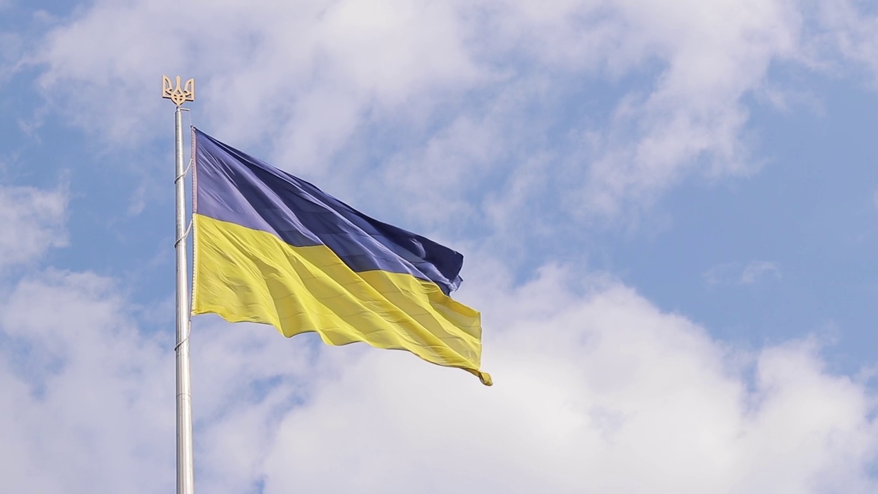多云的天空衬托着旗杆上的乌克兰国旗和国徽视频素材