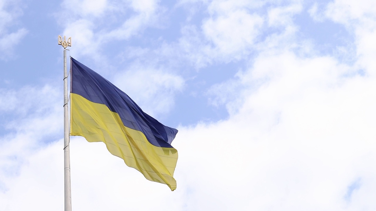 多云的天空衬托着旗杆上的乌克兰国旗和国徽视频素材