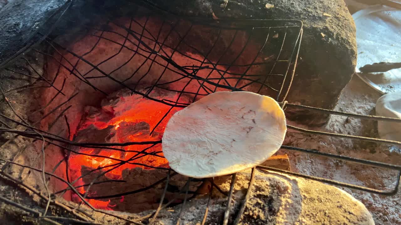 在土火余烬上加热玉米饼。视频下载