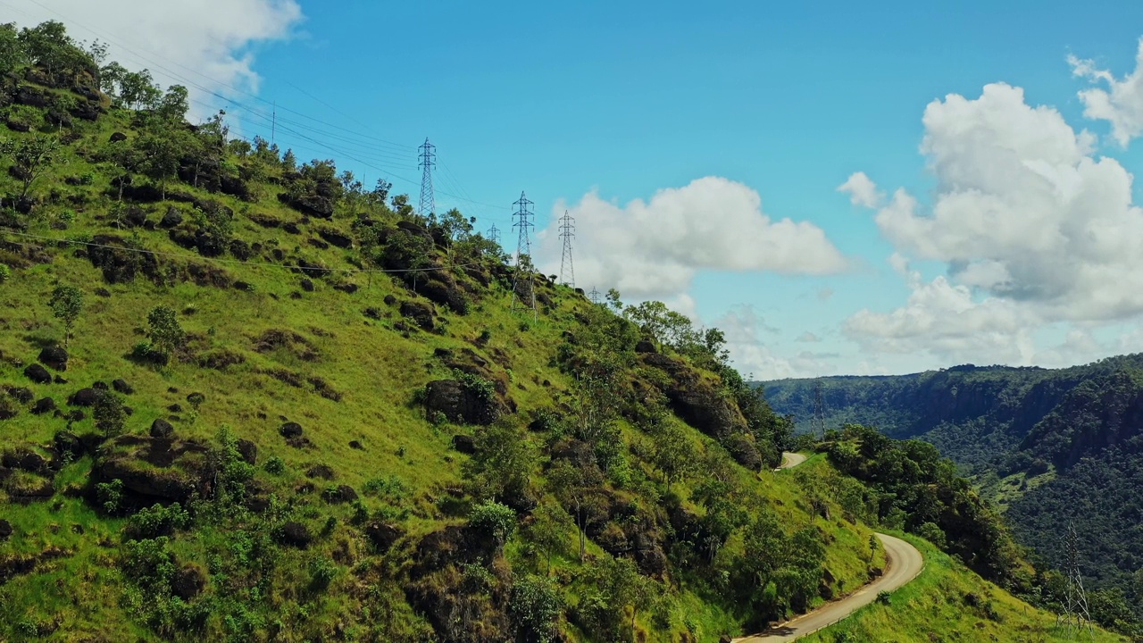 下山，露出陡峭的山坡和蜿蜒的道路。视频素材