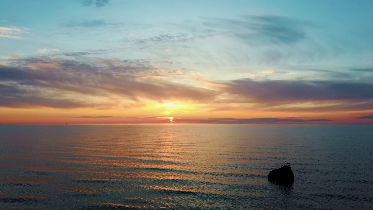 波罗的海日落鸟瞰图，拉脱维亚Pavilosta。美丽的金色日落在海滩海景。视频素材