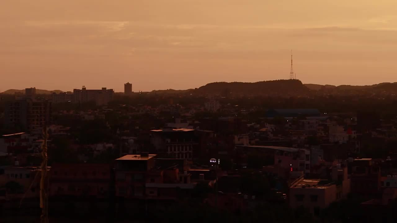 戏剧性的日落橙色天空与城市背光视图从山顶在晚上的时间流逝视频素材