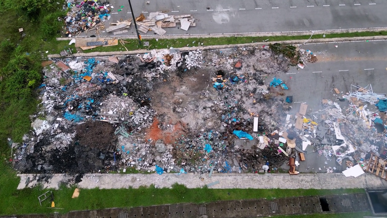 空中移动到柏油路和露天焚烧的垃圾场视频素材