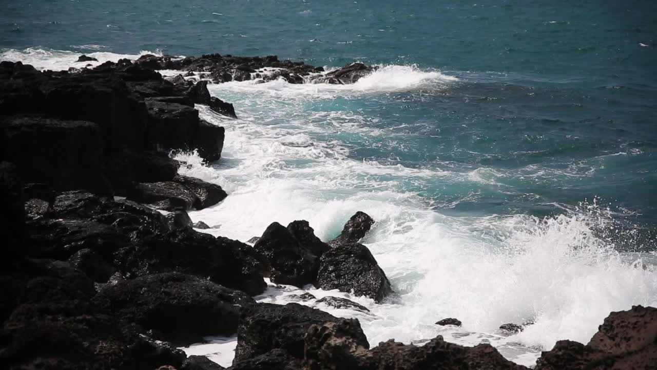 在济州岛海岸，白色的海浪冲击着黑色的玄武岩视频下载