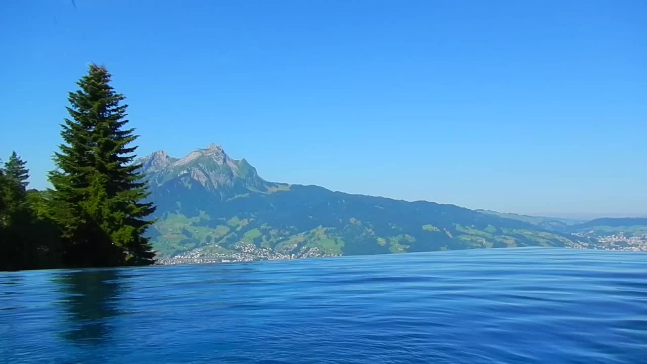 在一个阳光明媚的夏日，拥有山顶景色皮拉图斯的无限游泳池视频素材