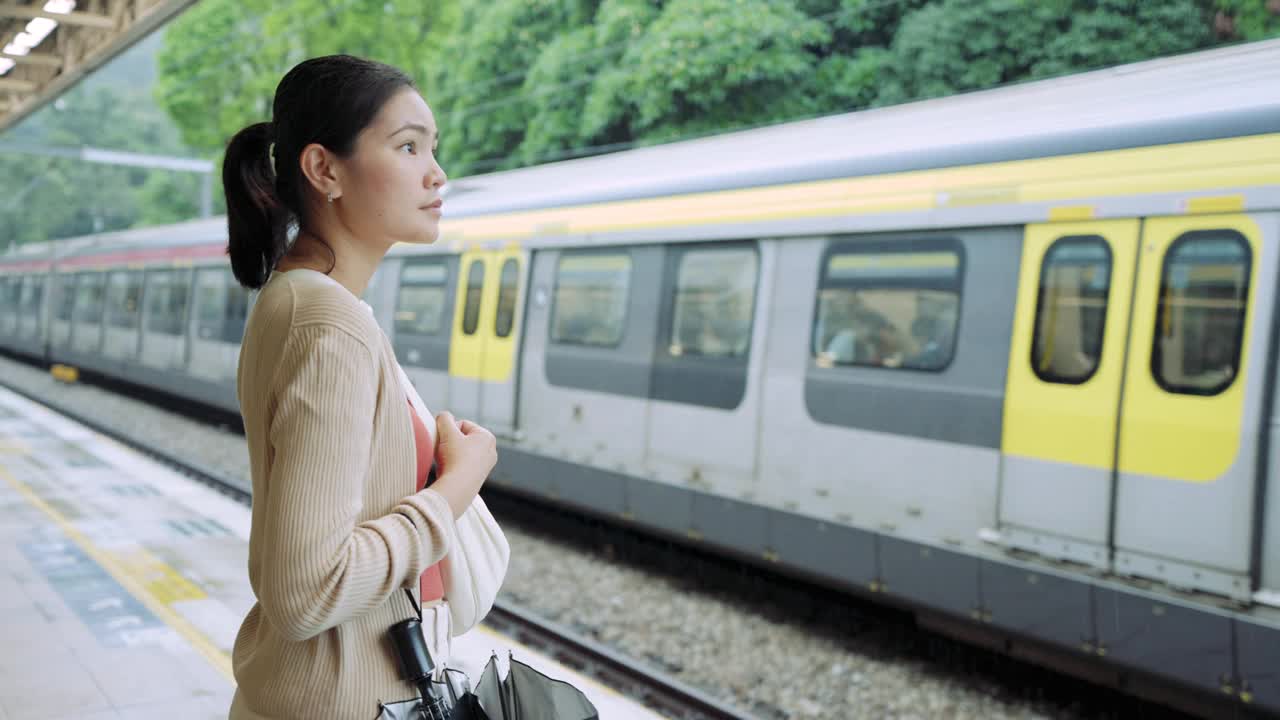 乘坐通勤火车旅行。一名女子在等火车时用手机打电话。视频素材