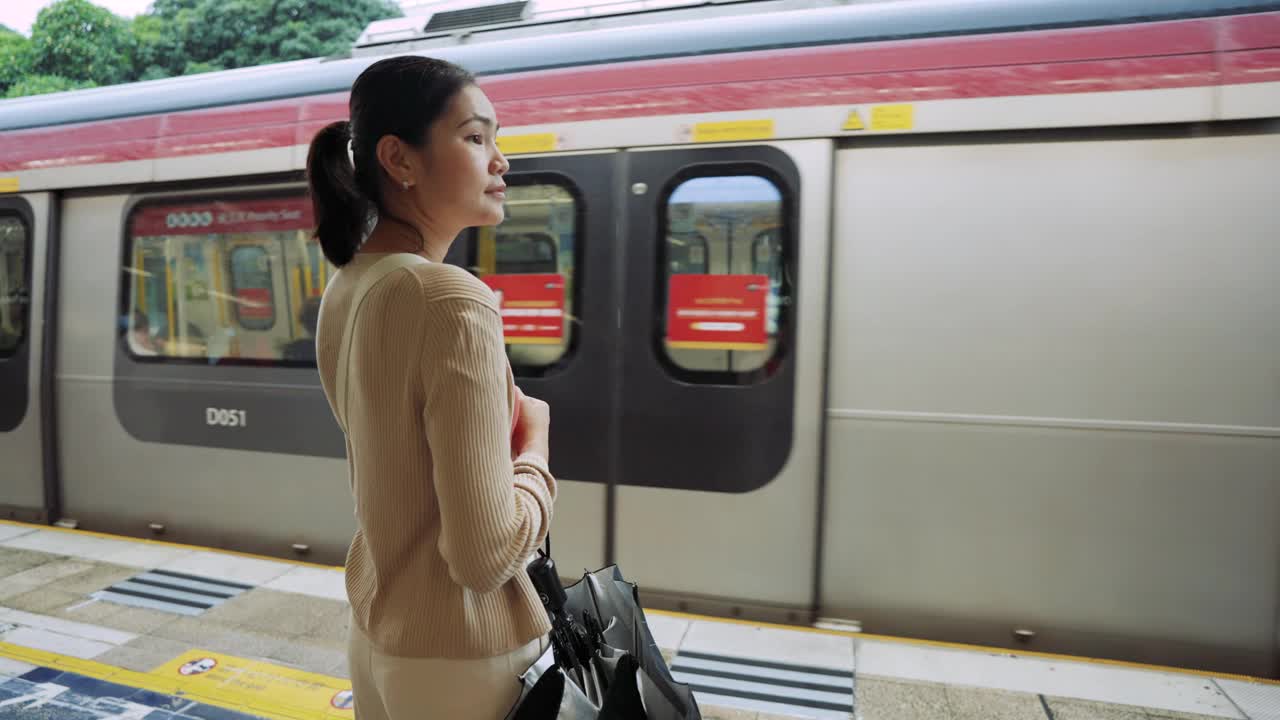 乘坐通勤火车旅行。一名女子在等火车时用手机打电话。视频素材