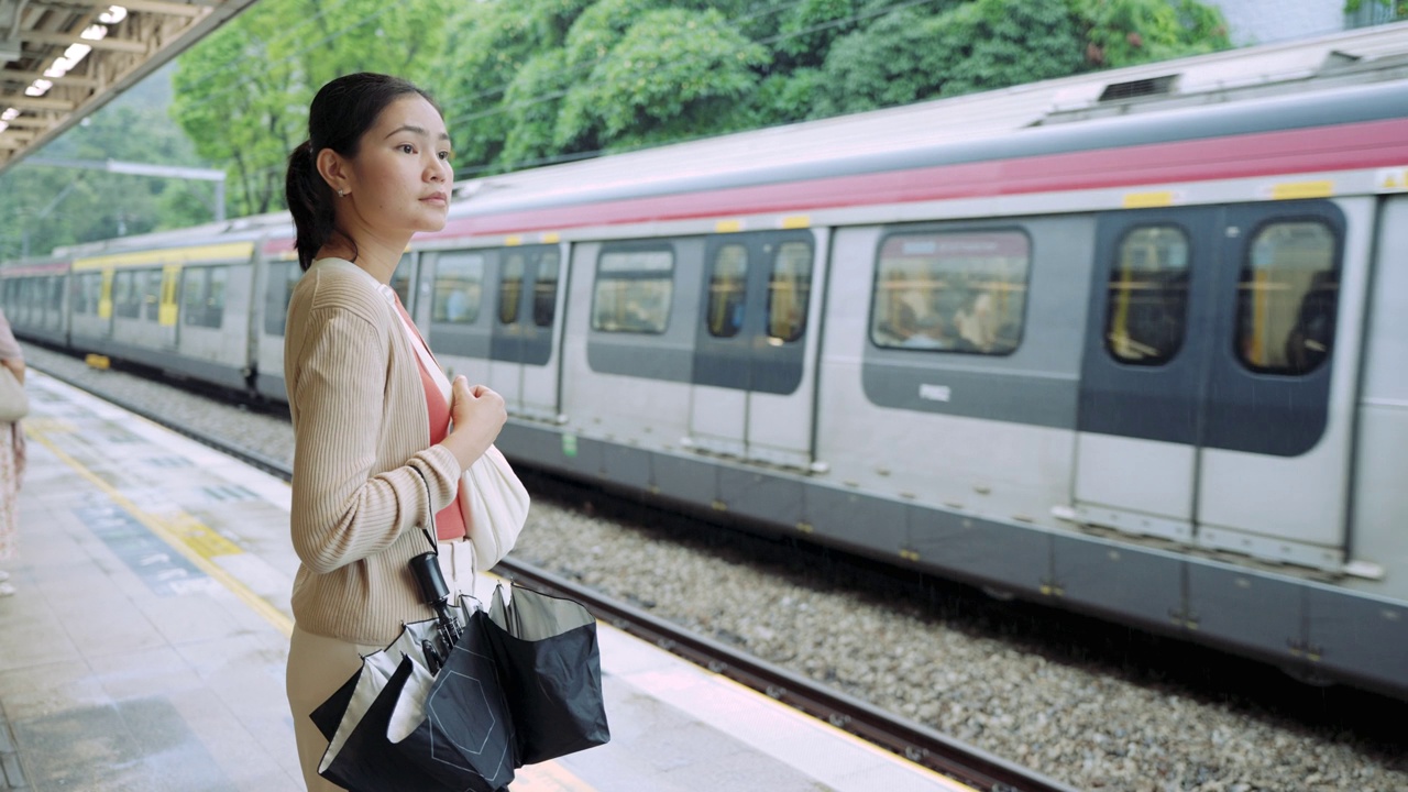 乘坐通勤火车旅行。一名女子在等火车时用手机打电话。视频素材