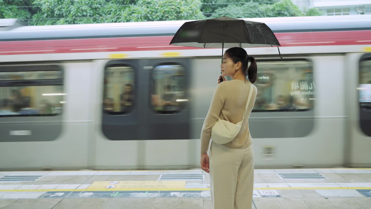 乘坐通勤火车旅行。一名女子在等火车时用手机打电话。视频素材