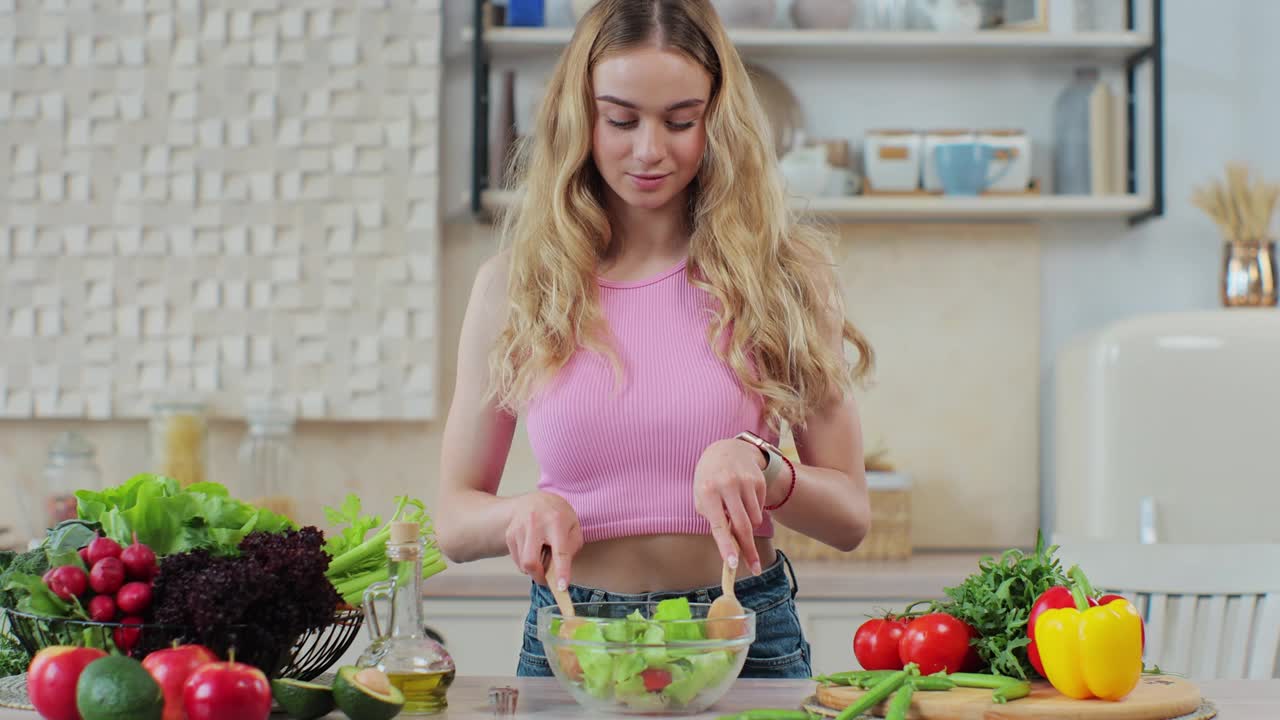 女性用勺子搅拌新鲜美味的沙拉中的蔬菜。健康饮食的概念。准备新鲜蔬菜沙拉。视频素材