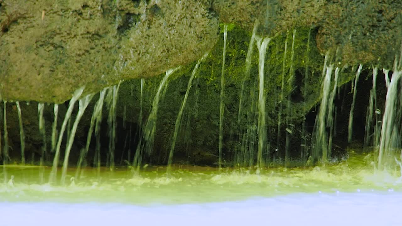 水滴穿过瀑布的岩石，特写。视频素材