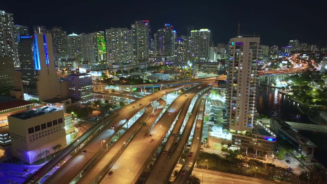 鸟瞰美国高速公路交汇处的夜间与快速行驶的车辆在迈阿密市，佛罗里达州。从上面看美国的交通基础设施视频素材