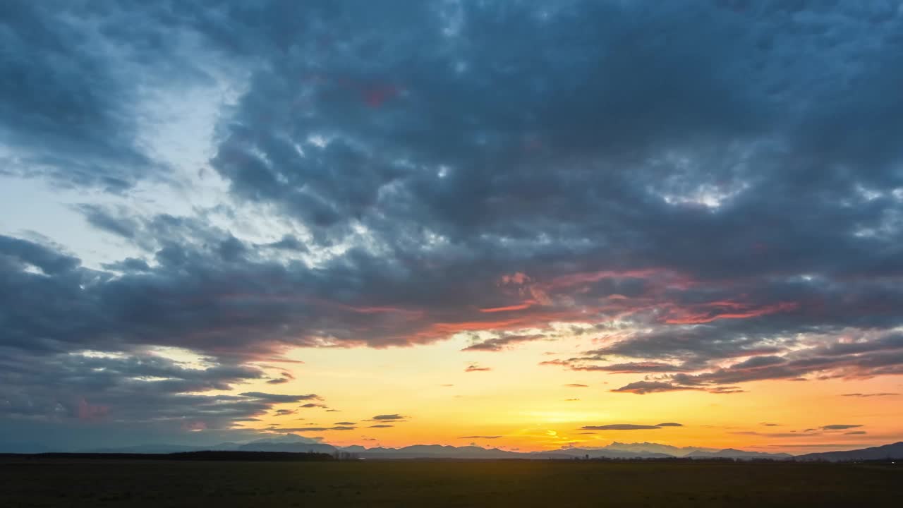 随着时间的推移，夕阳和许多黑暗的雨云在景观视频下载