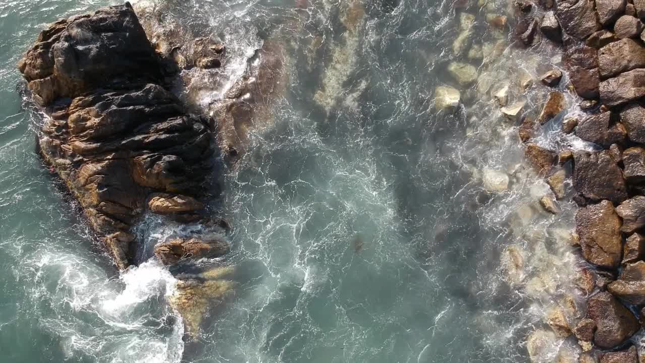 海浪冲击着韩国朱文镇海岸线上的岩石，无人机俯视图视频素材