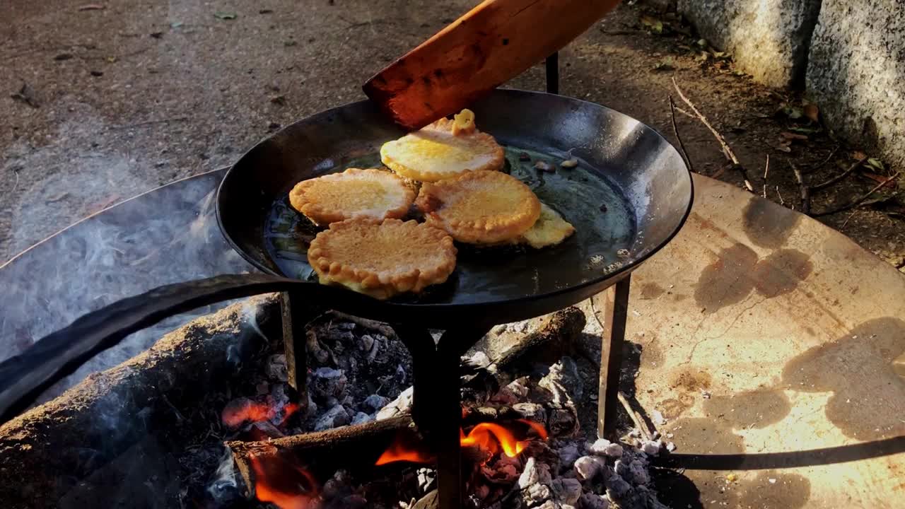 在燃烧的篝火上煎薄饼当早餐视频素材