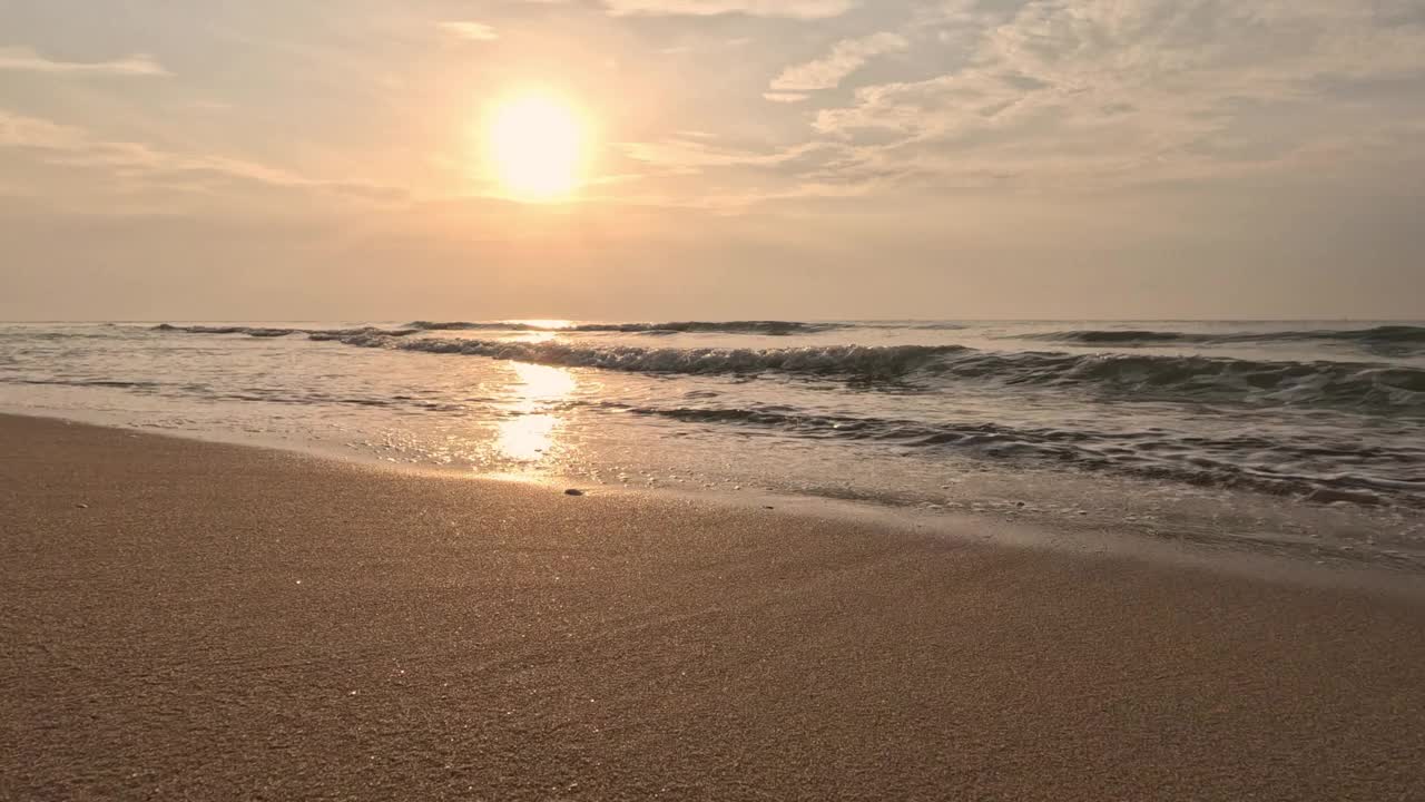 在日出或日落的热带海滩上，波浪飞溅。视频素材