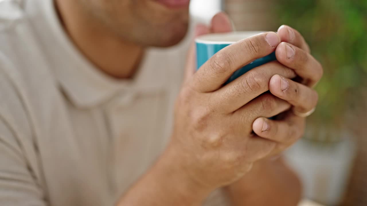 年轻的西班牙人坐在餐厅的桌子上喝咖啡视频素材