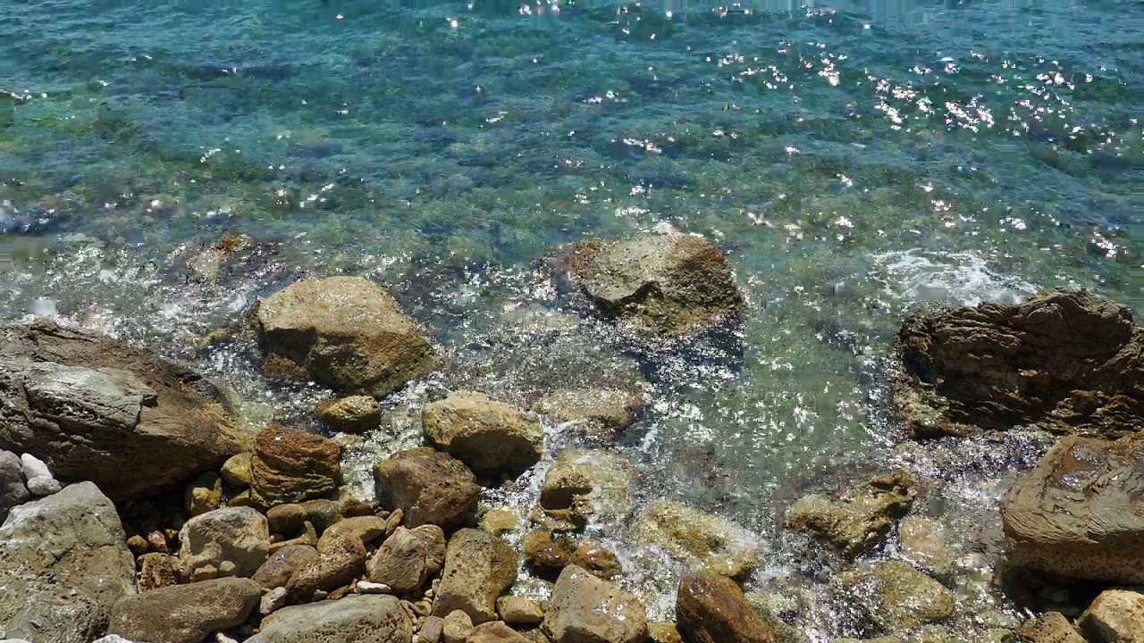 透明的海盐水质感。水面和涟漪的俯视图。海水海浪背景。长满海藻的岩石底部。浪花拍打着岩石。黑山，Herceg Novi视频素材