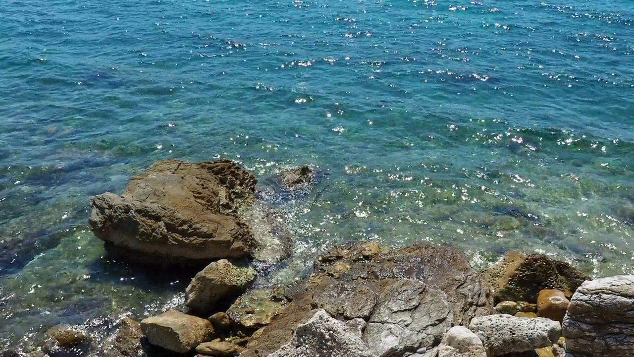 透明的海盐水质感。水面和涟漪的俯视图。海水海浪背景。长满海藻的岩石底部。浪花拍打着岩石。黑山，Herceg Novi视频素材