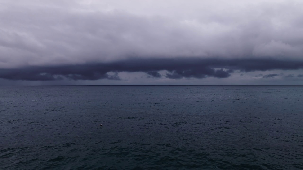 风暴云和雨在海上，黑暗的风暴云通过视频，高质量的镜头云在海上和海浪的背景视频素材