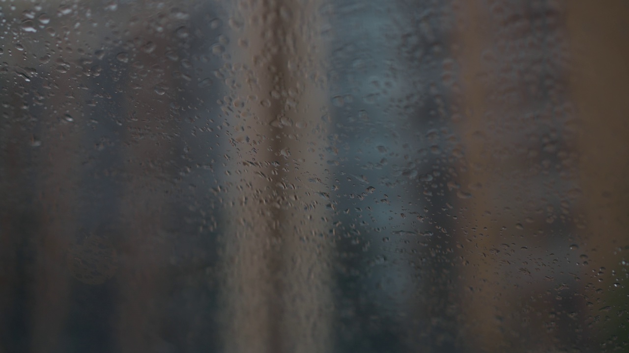 阴天的春夏秋日，玻璃上的雨滴特写。窗外下雨的特写镜头。视频素材