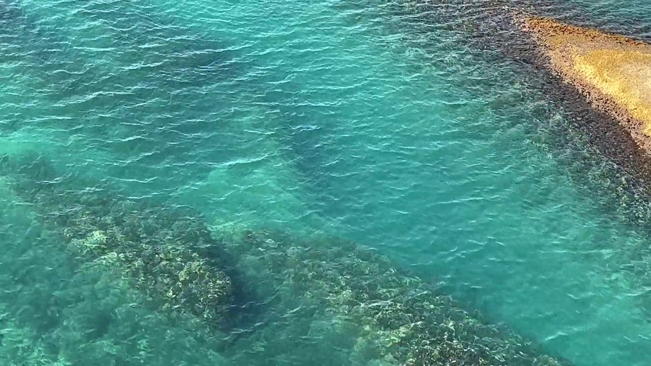 海水海水蓝蓝的绿松石清澈的水面闪闪发光的海景鸟瞰视频素材