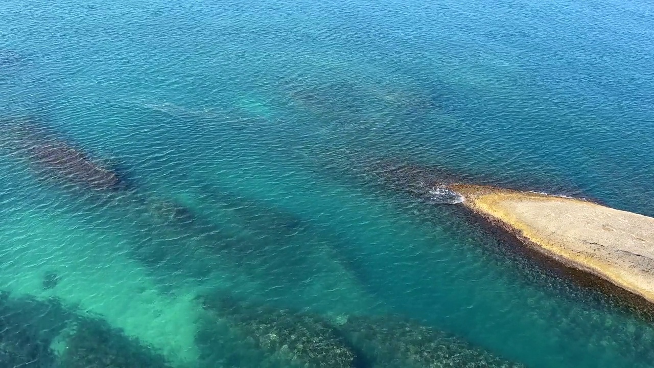 蓝绿色的海水和岩石海岸。视频素材