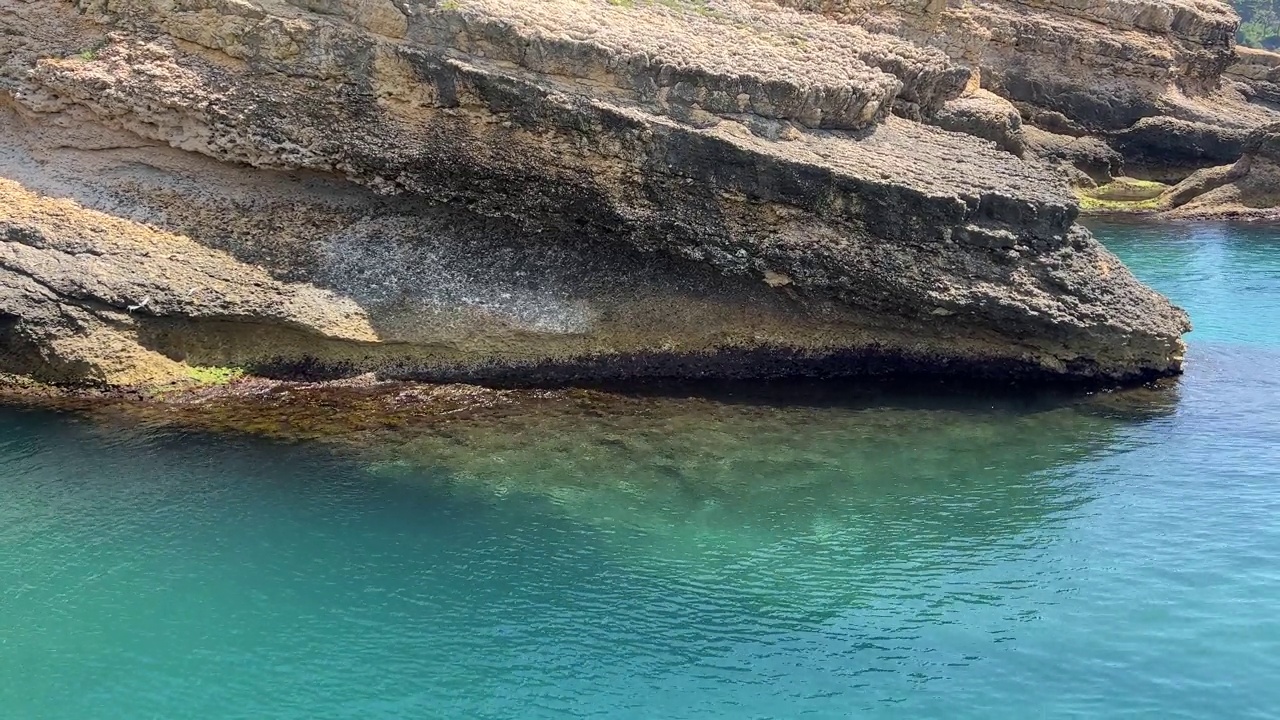 清澈的大海，蓝绿色的海水和岩石海岸。视频素材