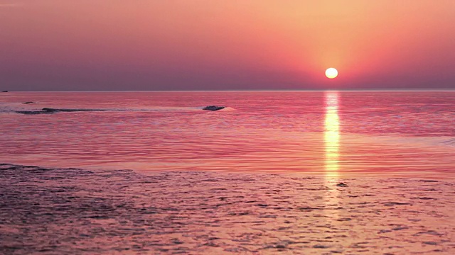 多色的日出掠过海浪。视频素材