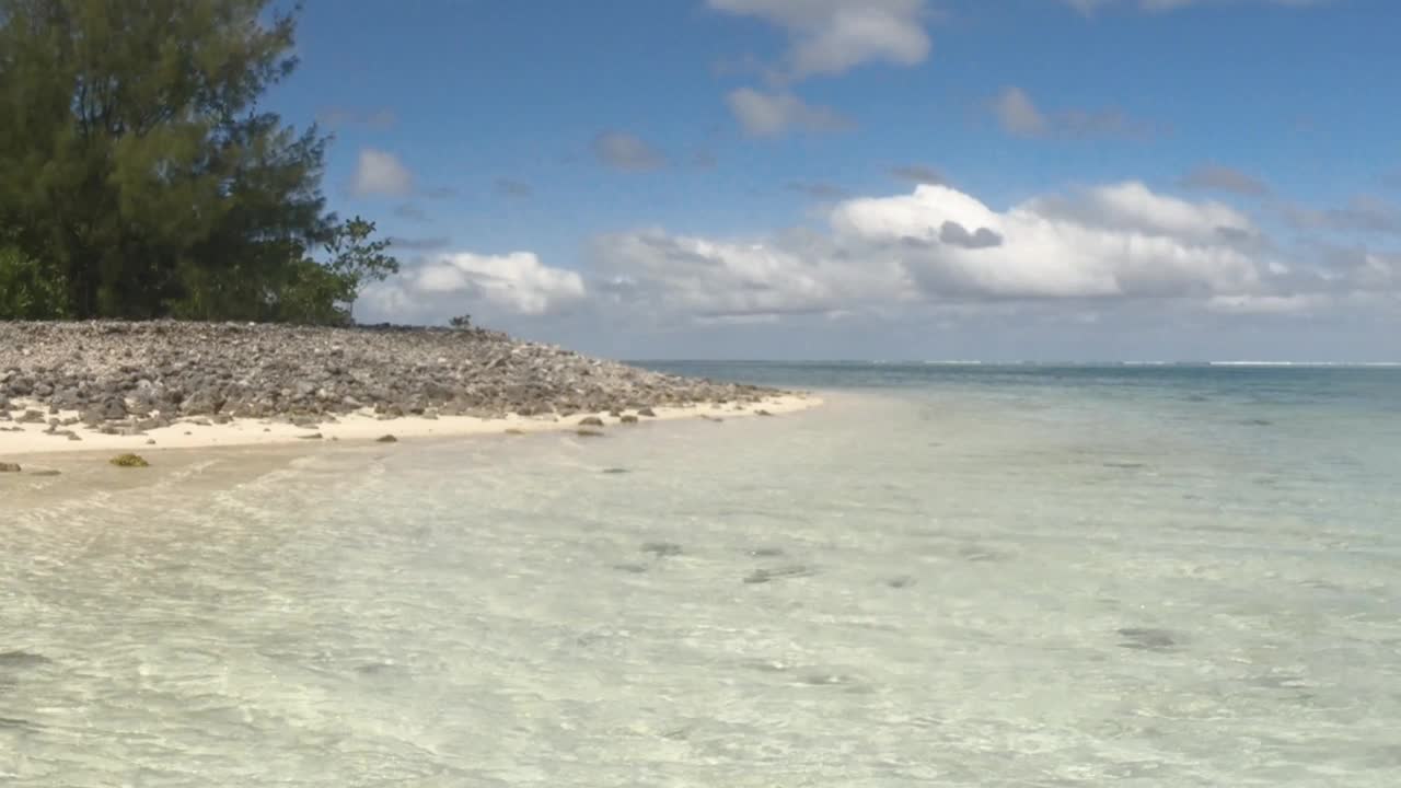 仍然浅海的看法，海盐清澈的水看向地平线绿松石泻湖和沙洲沙滩和植被在好天气，阳光，宁静的海水在太平洋岛屿视频素材