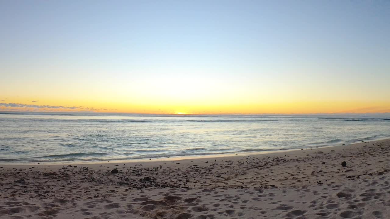 延时拍摄的静态视图从橙色的日落日落在遥远的海洋，海水咸水地平线从沙滩边在蓝色的天空好天气，湍流的水，平静的放松视频素材