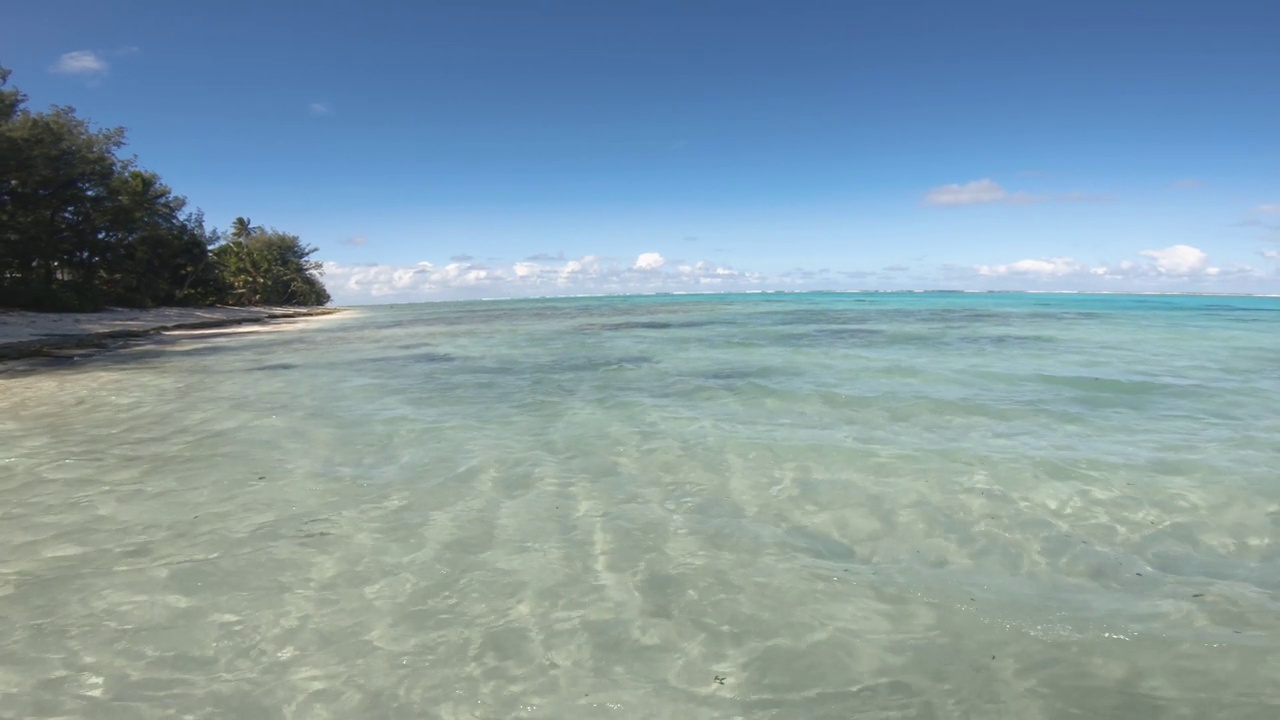 仍然浅海的看法，海盐清澈的水看向地平线绿松石泻湖和沙洲沙滩和植被在好天气，阳光，宁静的海水在太平洋岛屿视频素材