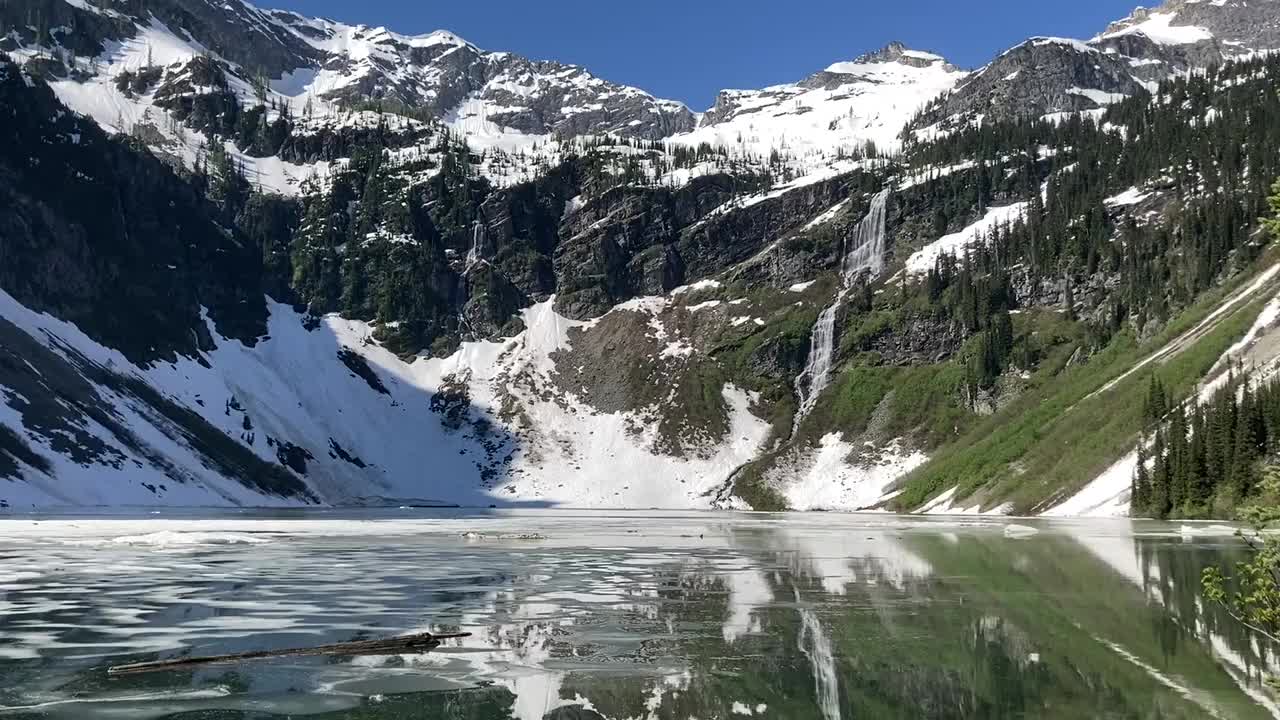 美丽的雨湖部分冻结与雪峰-北喀斯喀特国家公园视频素材