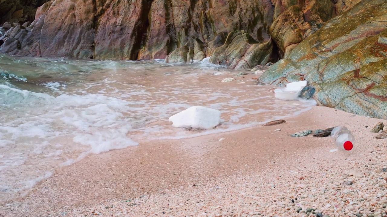 热带海滩上杂乱的景象令人毛骨悚然。海浪冲刷着海滩上的垃圾。塑料正在慢慢杀死我们的海洋。倾倒在海边的垃圾对我们的星球和我们的生存构成了威胁视频素材