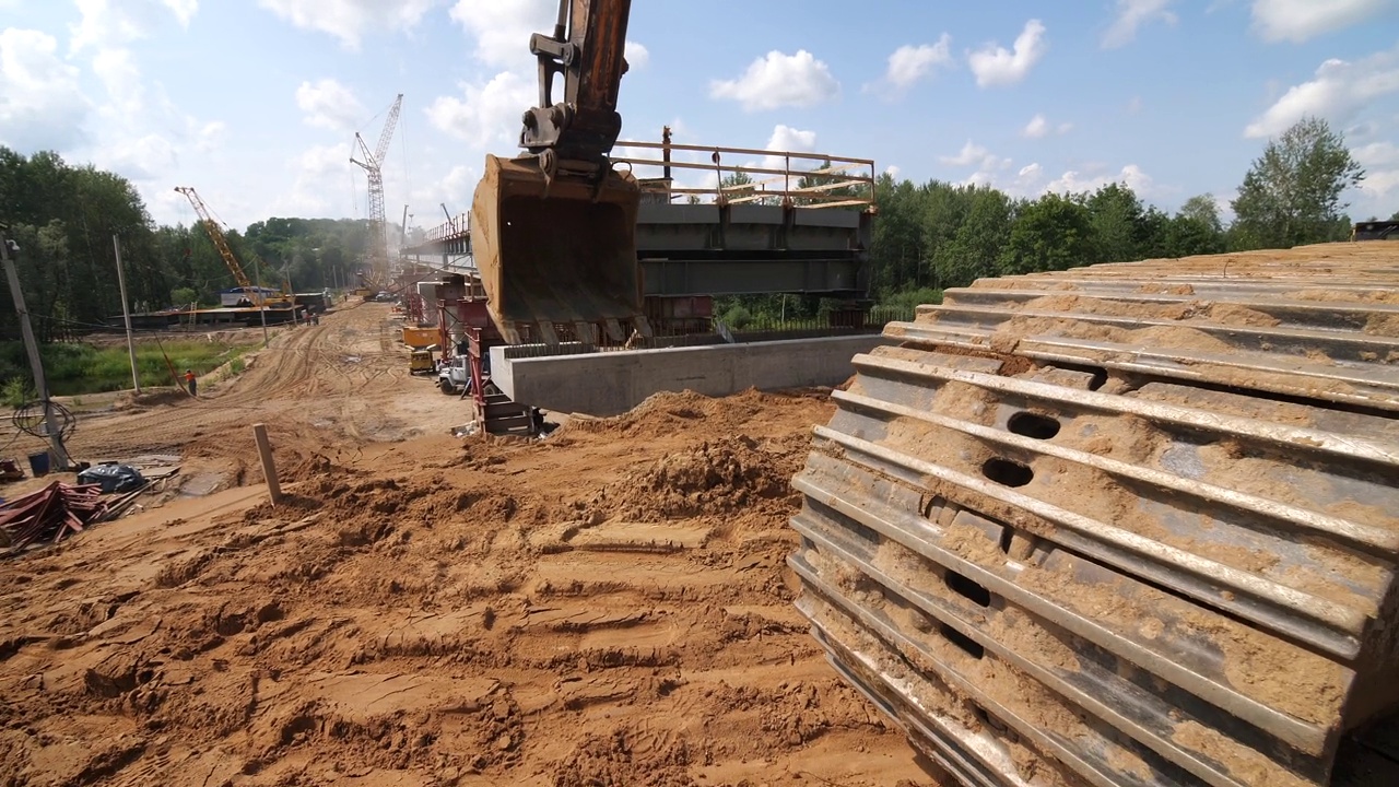 挖掘机工作在一个建筑工地，建造一座新桥的过程中视频素材