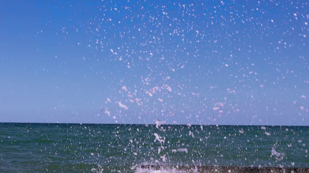 海浪在岸边翻滚。天空的蓝色映照在海水里。视频下载