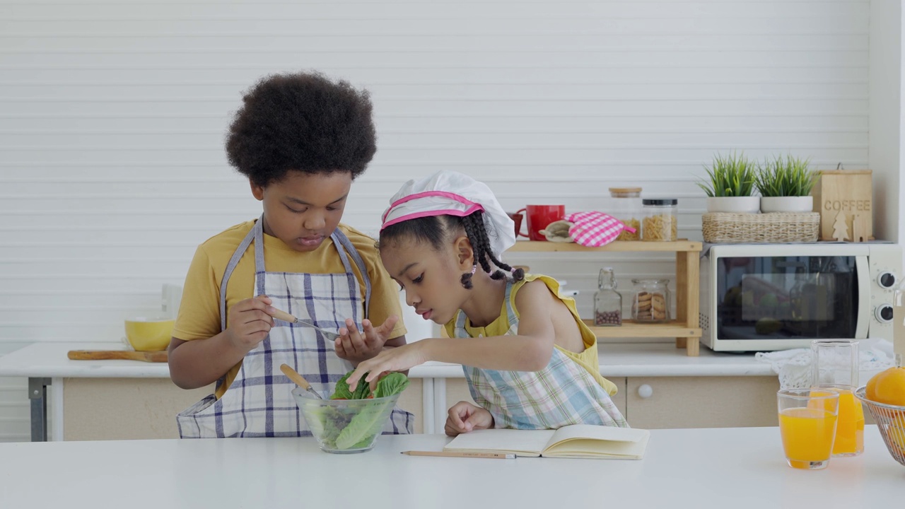 小孩子在厨房做饭。孩子们的生活方式和暑假的室内活动。视频素材