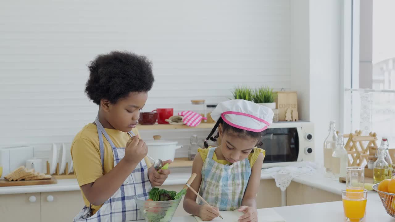 小孩子在厨房做饭。孩子们的生活方式和暑假的室内活动。视频素材