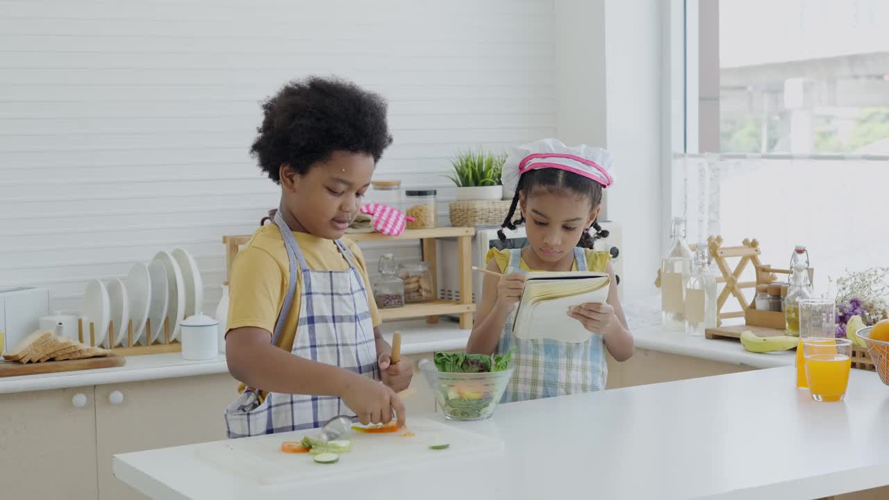 小孩子在厨房做饭。孩子们的生活方式和暑假的室内活动。视频素材