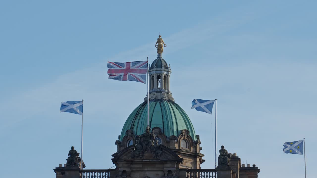 在蓝天背景下，英国爱丁堡老城，英国国旗和苏格兰国旗在博物馆的建筑圆顶上的4K实时画面视频素材