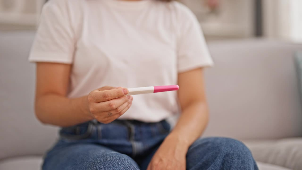 年轻漂亮的西班牙女人看起来怀孕测试在家里思考视频素材