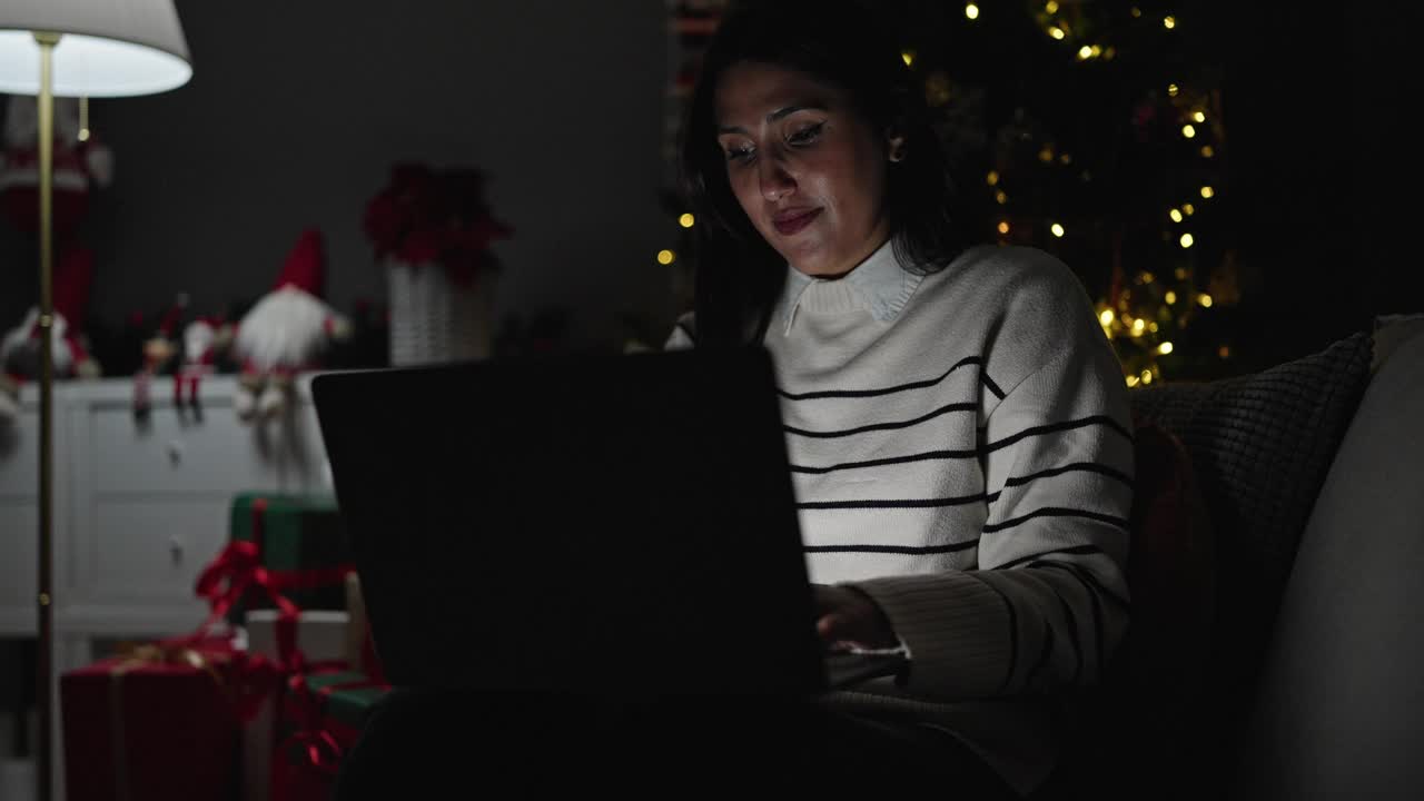 年轻漂亮的西班牙女人在家里用笔记本电脑庆祝圣诞节视频素材