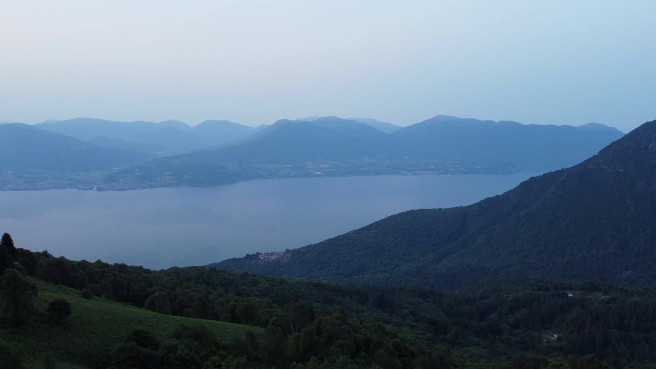 空中景观的绿色森林丘陵与湖景在日出视频素材