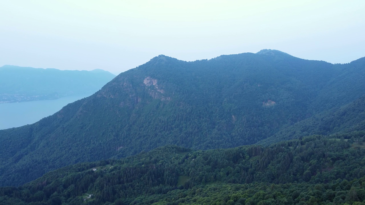 灰色天空下，无人机在森林山丘和奥格比奥湖上空拍摄的画面视频素材